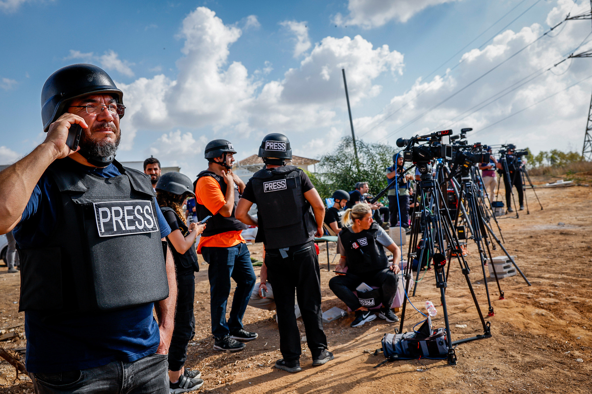 Foreign and Israeli journalists stand on a hill overlooking the Gaza Strip in the city of Sderot, southern Israel, October 19, 2023. (Nati Shohat/Flash90)