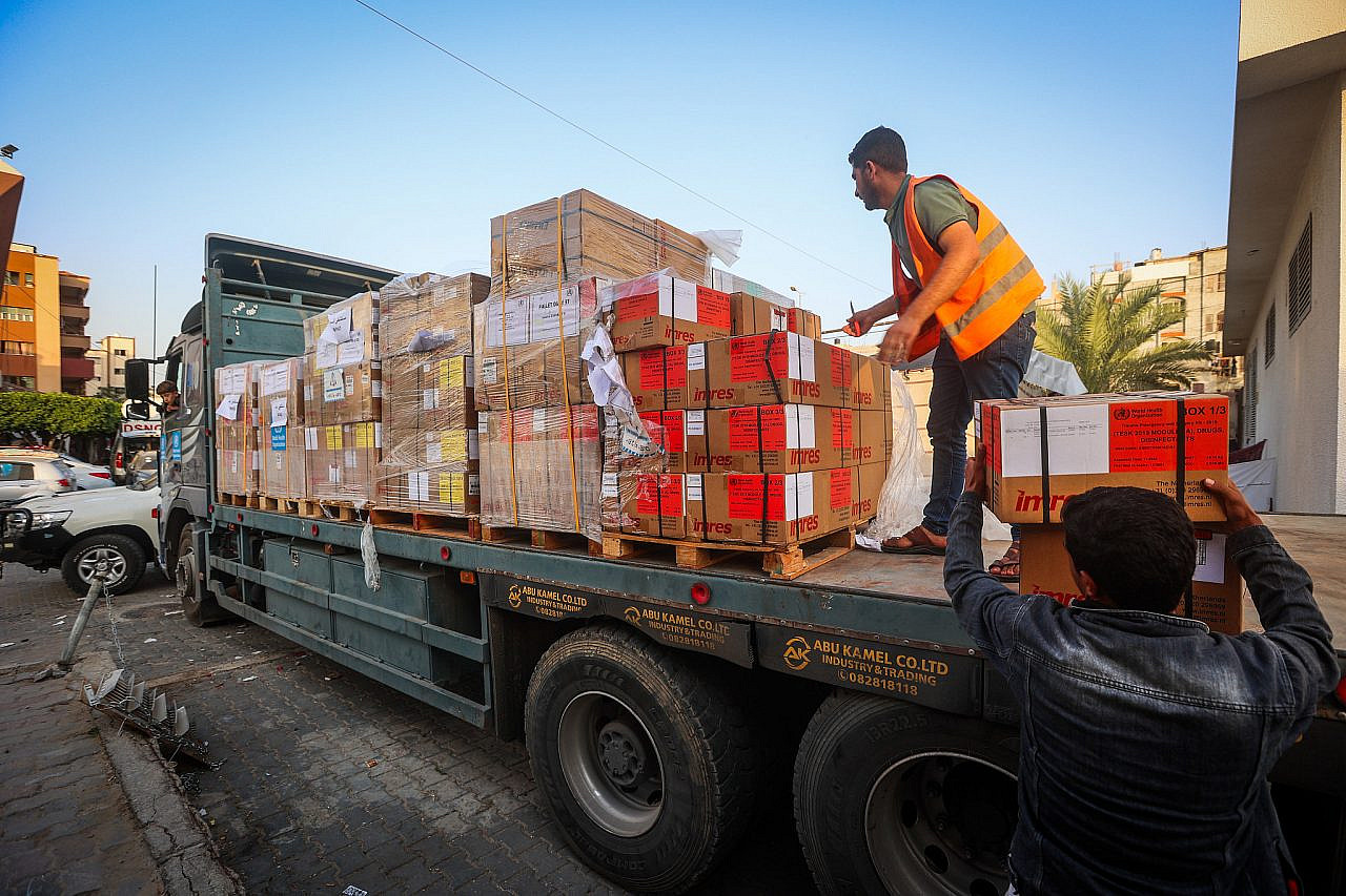 Palestinians unload medical aid from a truck at Al-Nasser Hospital in Khan Younis, southern Gaza Strip, October 23, 2023. (Atia Mohammed/Flash90)