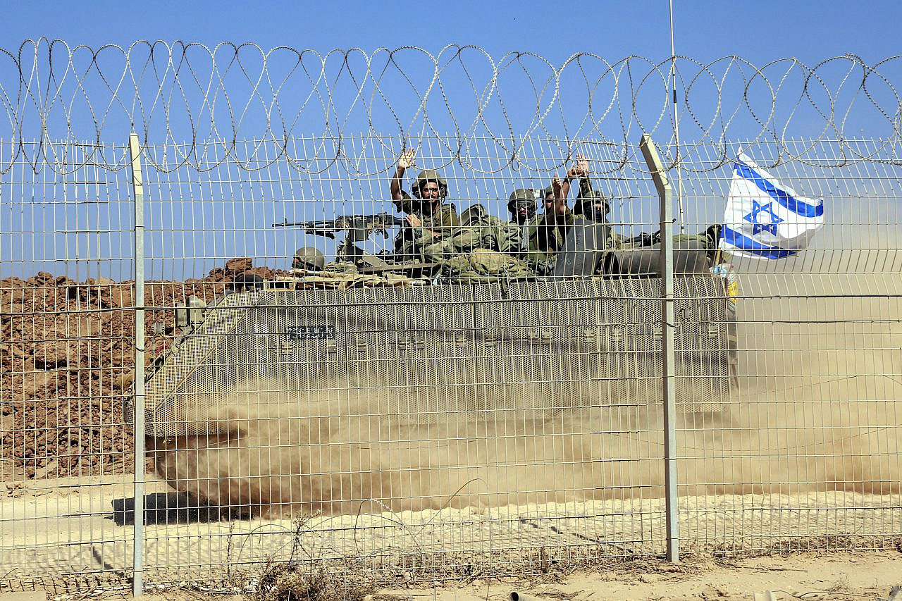 Israeli soldiers seen behind the fence of Kibbutz Be'eri, near the Israeli-Gaza fence, southern Israel. October 25, 2023. (Yossi Zamir/Flash90)