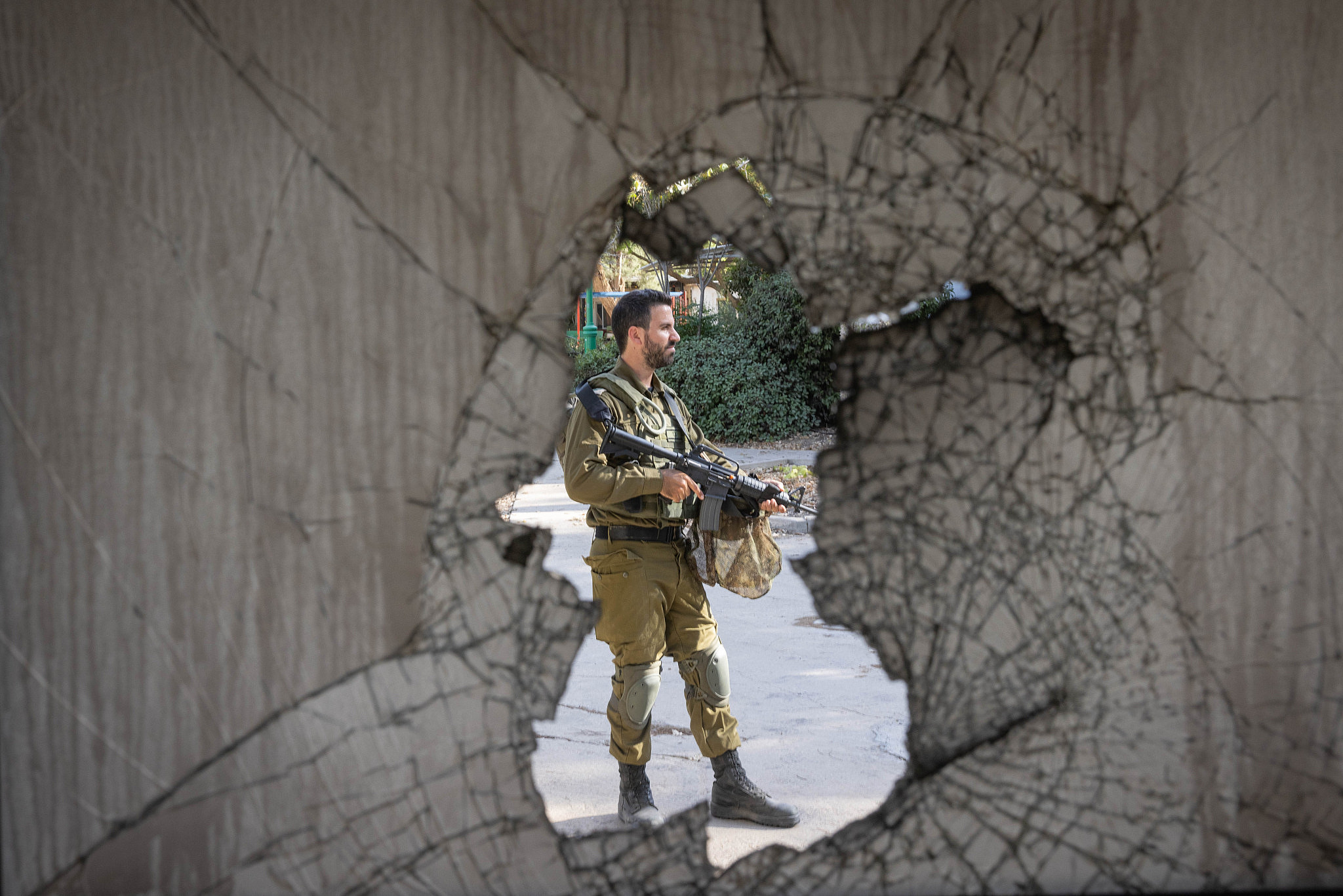 An Israeli soldier is seen among the destruction caused by Hamas militants in Kibbutz Nir Oz during their October 7 raid, southern Israel, October 30, 2023. (Chaim Goldberg/Flash90)