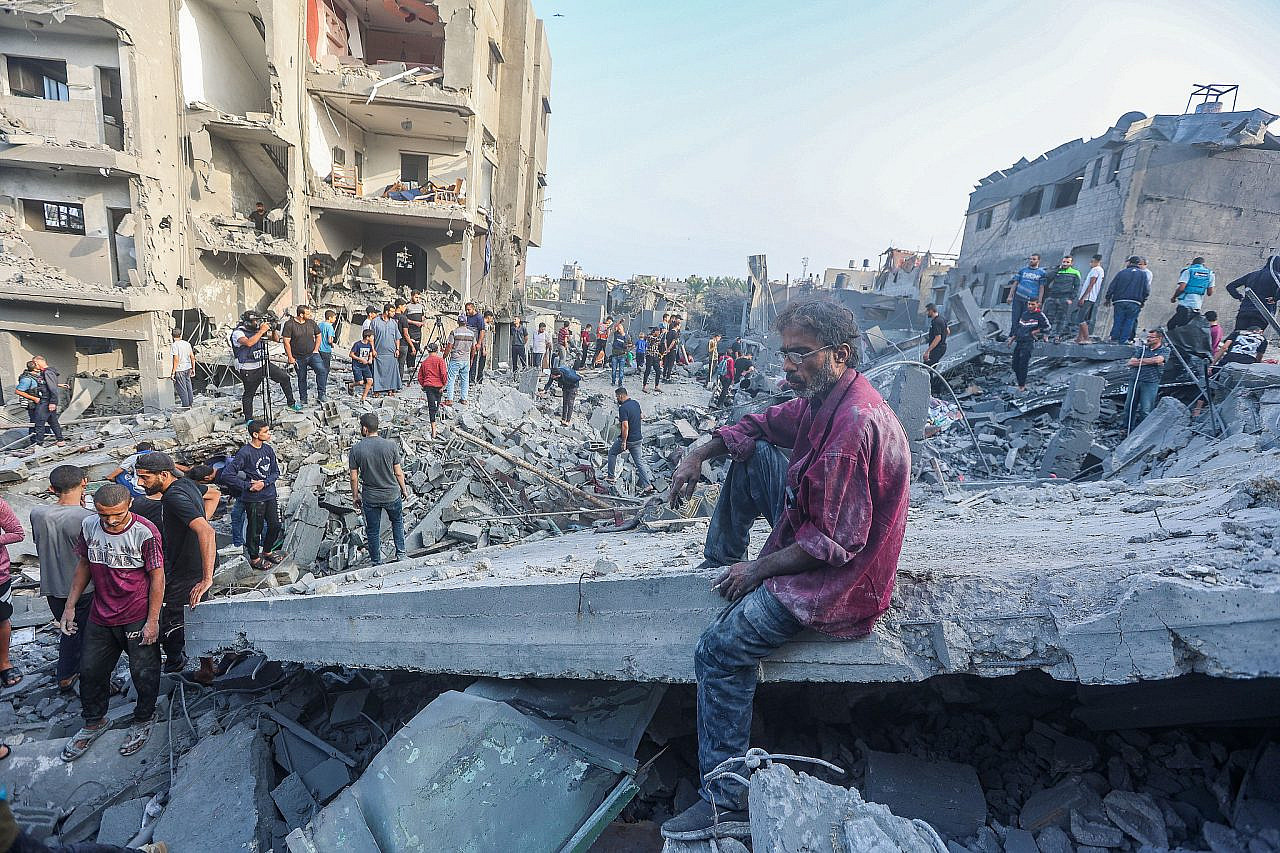 Des Palestiniens devant les décombres d’un bâtiment détruit après une frappe aérienne israélienne dans le centre de la bande de Gaza, le 5 novembre 2023. (Atia Mohammed/Flash90)