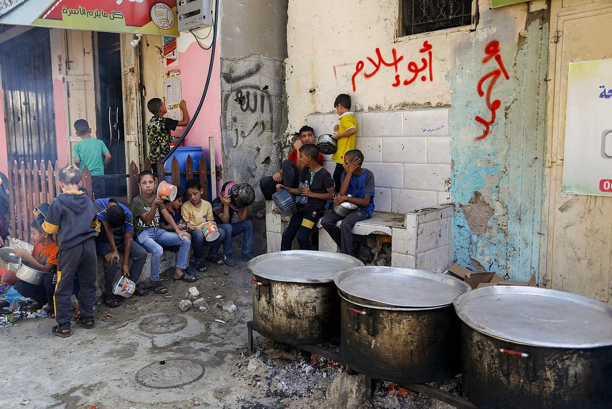 Young Palestinians wait for a hot meal prepared by volunteers, in Rafah, in the southern Gaza Strip, November 10, 2023. (Abed Rahim Khatib/Flash90)