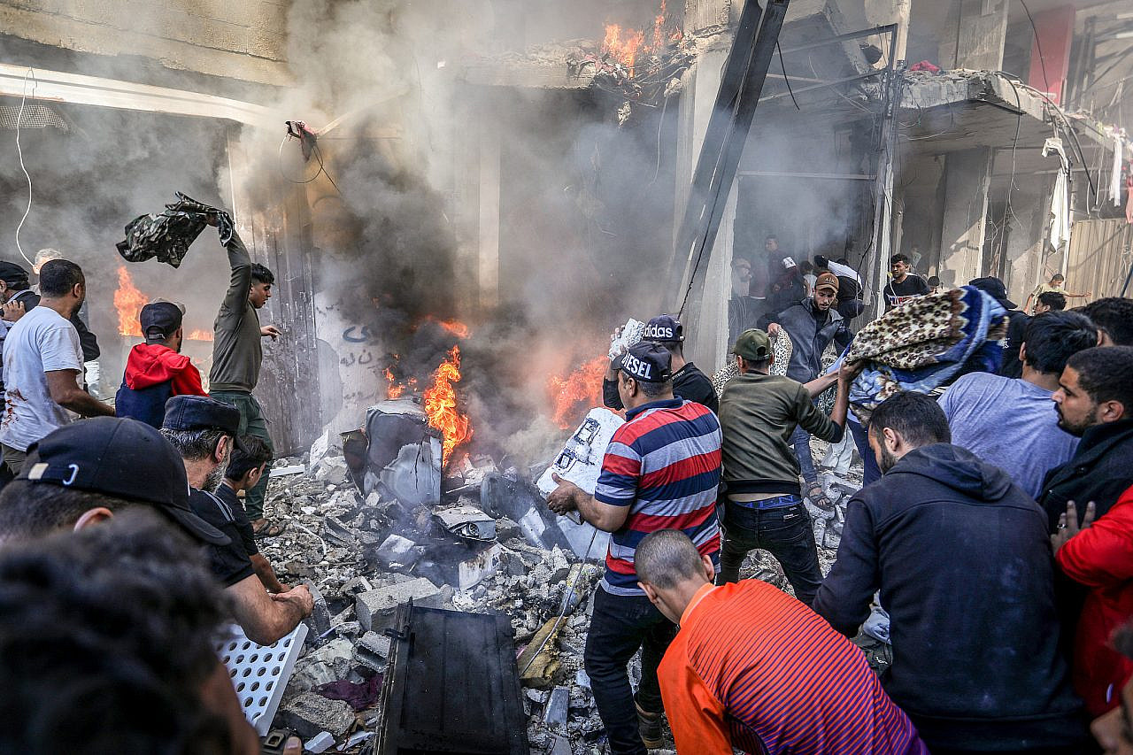 Palestinians try to put out a fire after an Israeli airstrike on a house in the Shaboura refugee camp in the city of Rafah, southern of the Gaza Strip, on November 17, 2023. (Abed Rahim Khatib/Flash90)