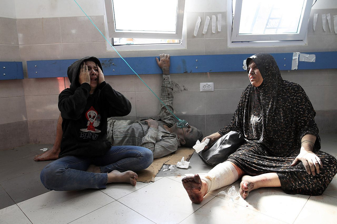 Wounded Palestinians are treated on the floor due to overcrowding at Al-Shifa Hospital, Gaza City, central Gaza Strip, October 18, 2023. (Mohammed Zaanoun/Activestills)