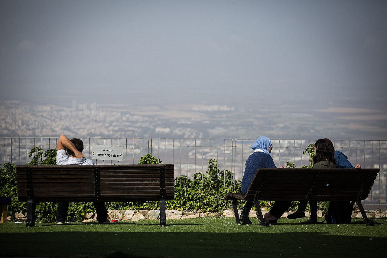 Students sit over a view of the city of Haifa and the Haifa Bay, at the outdoor area during their break at the University of Haifa, on April 11, 2016. (Hadas Parush/Flash90)