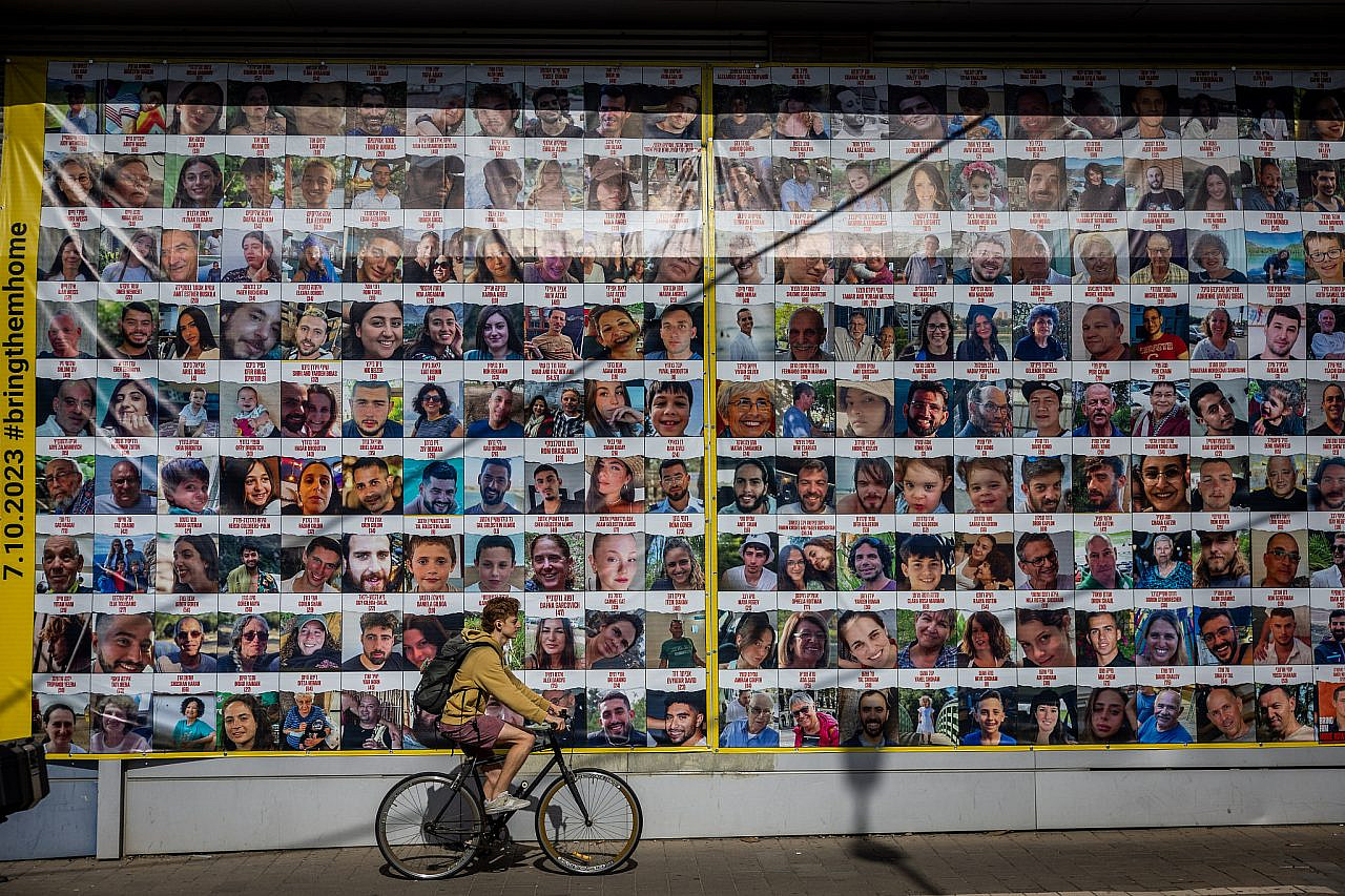 People seen next to pictures of civilians held hostage in Gaza, Jerusalem, November 24, 2023. (Yonatan Sindel/Flash90)
