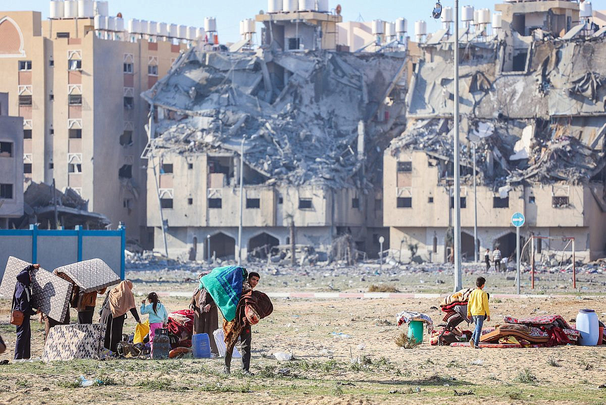 Des Palestiniens près de bâtiments détruits après une frappe aérienne israélienne à Khan Younis, dans le sud de la bande de Gaza, le 2 décembre 2023. (Atia Mohammed/Flash90)