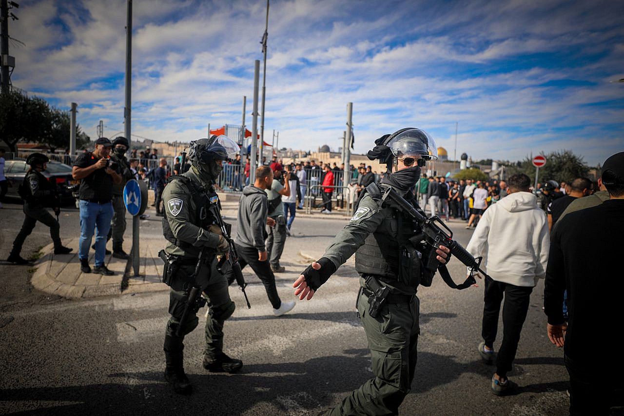 Israeli police guard while Palestinians perform Friday prayers in the occupied East Jerusalem neighborhood of Ras Al Amud, December 8, 2023. (Jamal Awad/Flash90)
