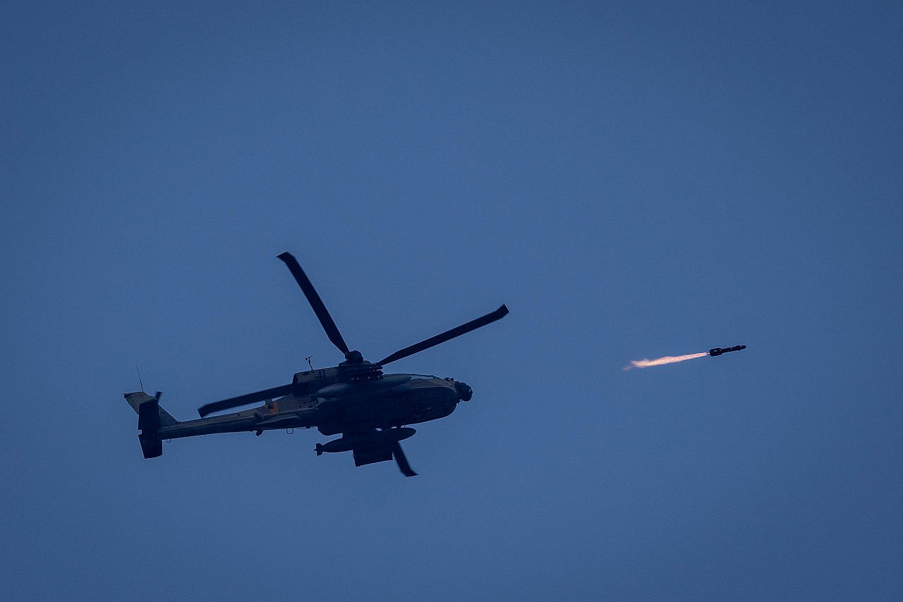 An Israeli combat helicopter firing a missile toward a target in the Gaza Strip, seen from the Israeli side of the fence, December 13, 2023. (Chaim Goldberg/Flash90)