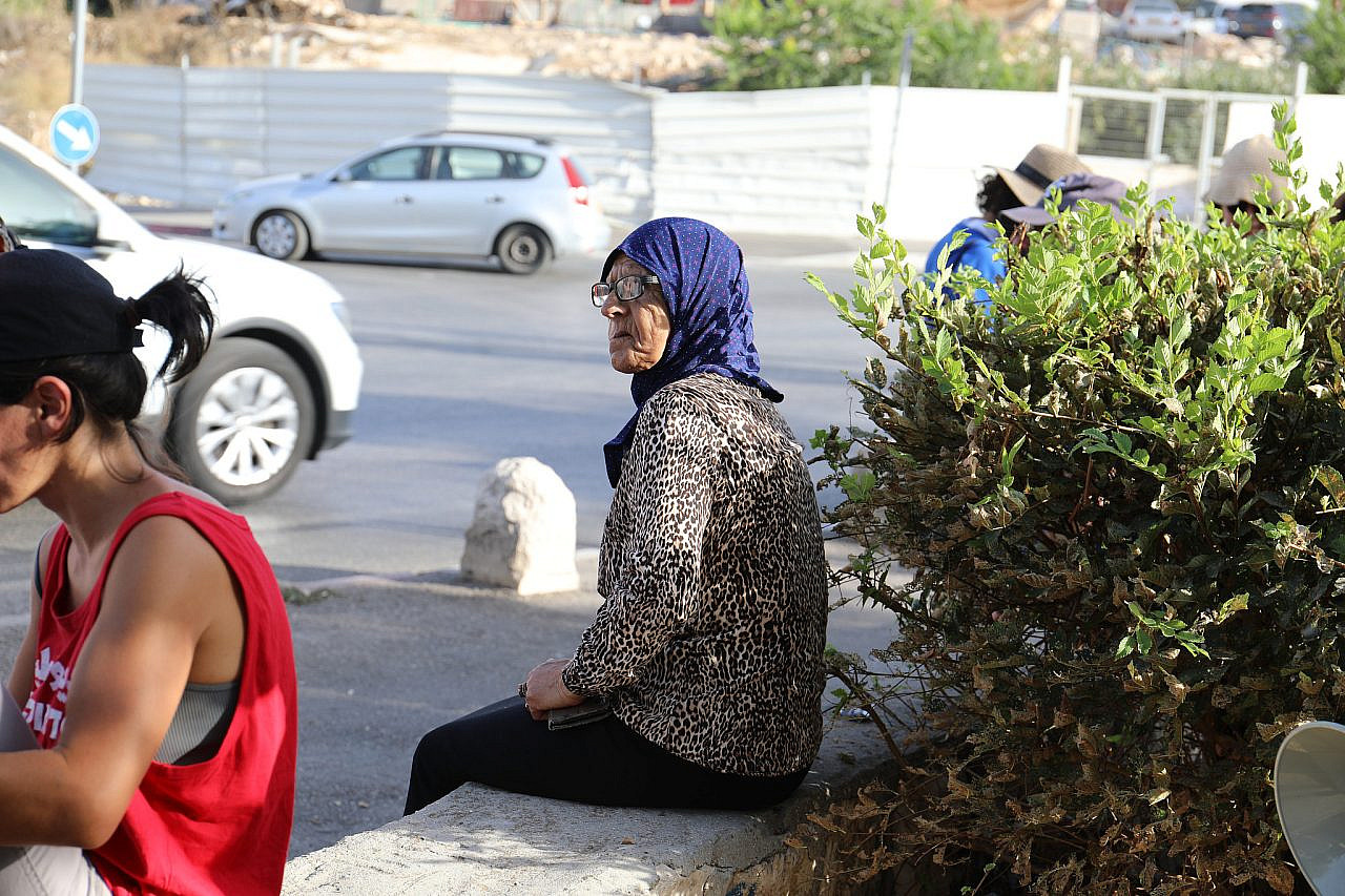 Fatma Salem sits on a wall ahead of a protest in Sheikh Jarrah, occupied East Jerusalem. (Yahel Gazit)