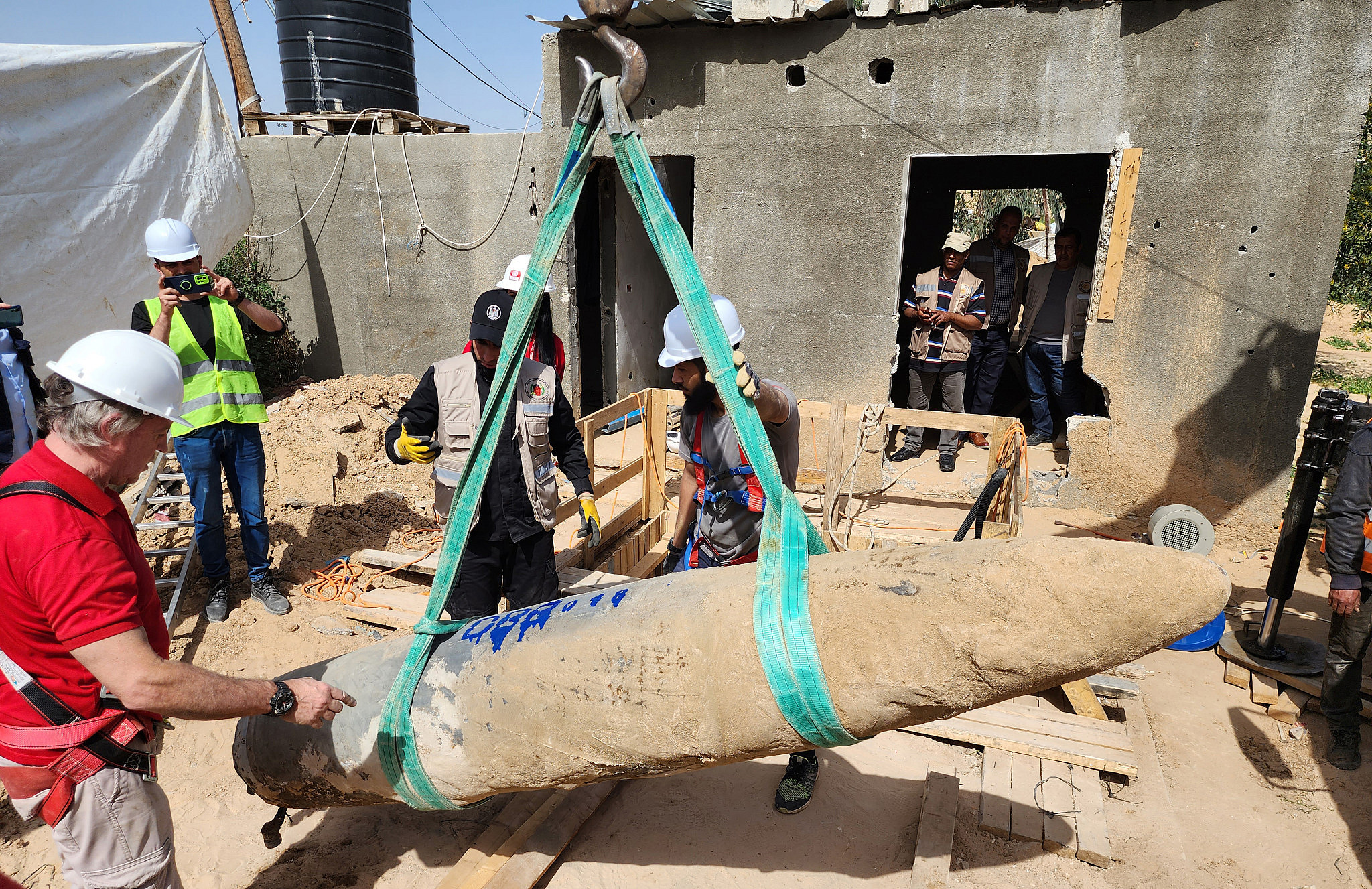 Palestinian police and members of the United Nations Mine Action Service (UNMAS) removing an Israeli bomb from the ground in Rafah, in the southern Gaza Strip, March 5, 2023. (Abed Rahim Khatib/Flash90)