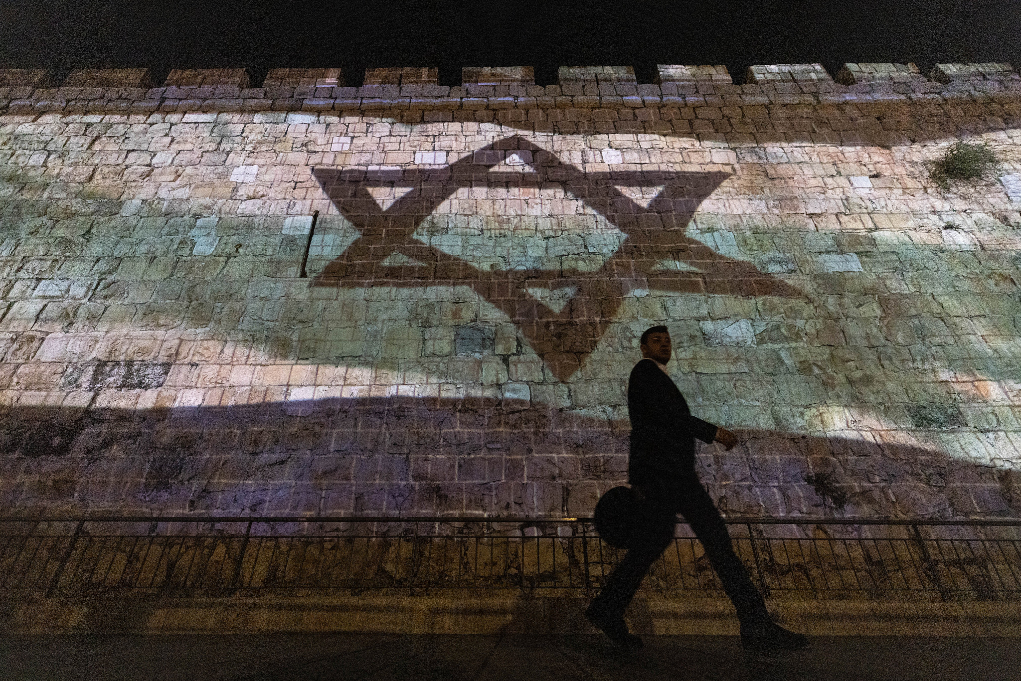The Israeli flag is screened on the walls of Jerusalem's Old City, November 7, 2023. (Chaim Goldberg/Flash90)