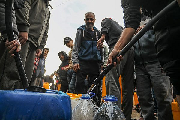 Palestinians collect drinking water in the city of Rafah, in the southern Gaza Strip, December 23, 2023. (Abed Rahim Khatib/Flash90)