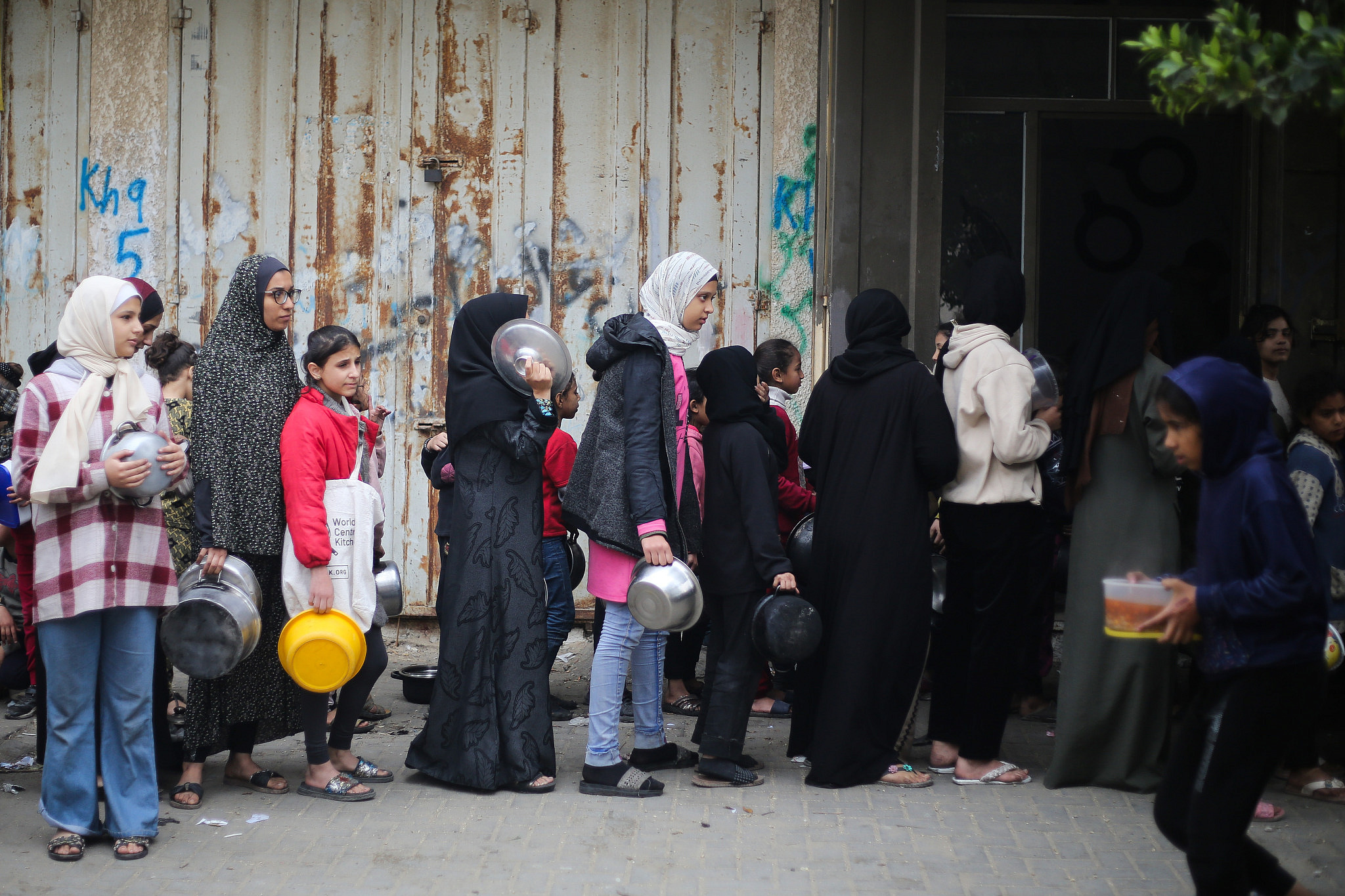 Palestinians stand in line to get soup in the city of Khan Younis, in the southern Gaza Strip, January 9, 2024. (Atia Mohammed/Flash90)