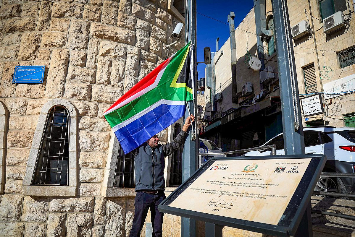 Bethlehem Municipality employees raise a South African flag as a sign of appreciation for their lawsuit against Israel to the International Court of Justice (ICJ), in the West Bank city of Bethlehem, January 16, 2024. (Wisam Hashlamoun/Flash90)