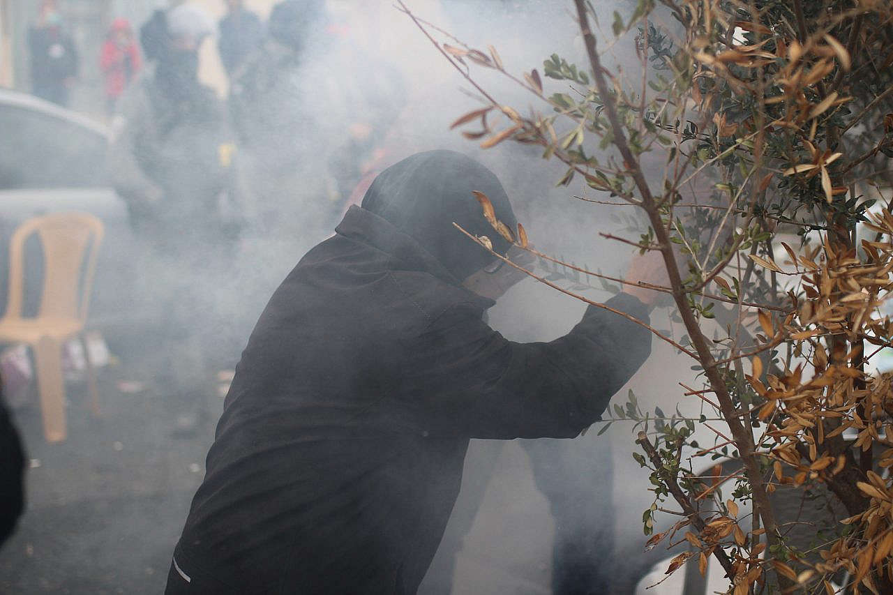 Fatma Salem shields her face from tear gas during a protest in Sheikh Jarrah, occupied East Jerusalem. (Yahel Gazit)