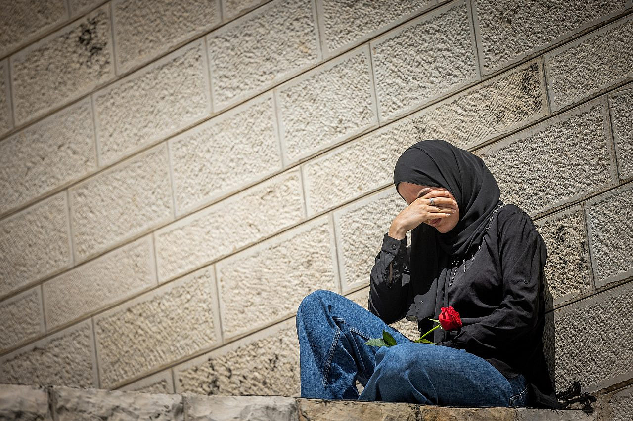 A Palestinian woman mourns outside St Joseph's Hospital in East Jerusalem, May 12, 2022. (Yonatan Sindel/Flash90)