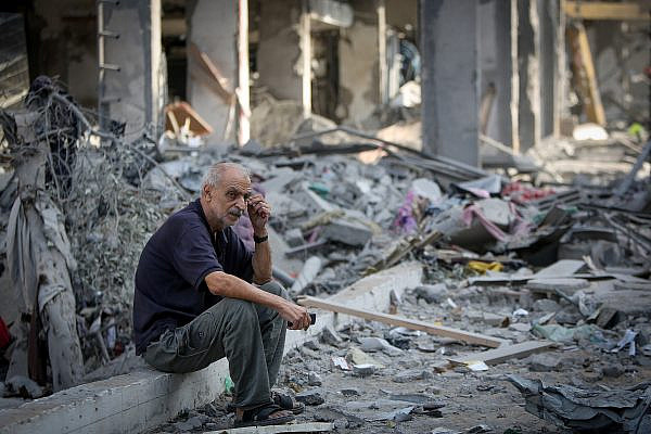 Palestinians walk through rubble of houses destroyed by Israeli airstrikes in the Jabalia area, northern Gaza Strip, October 11, 2023. (Atia Mohammed/Flash90)