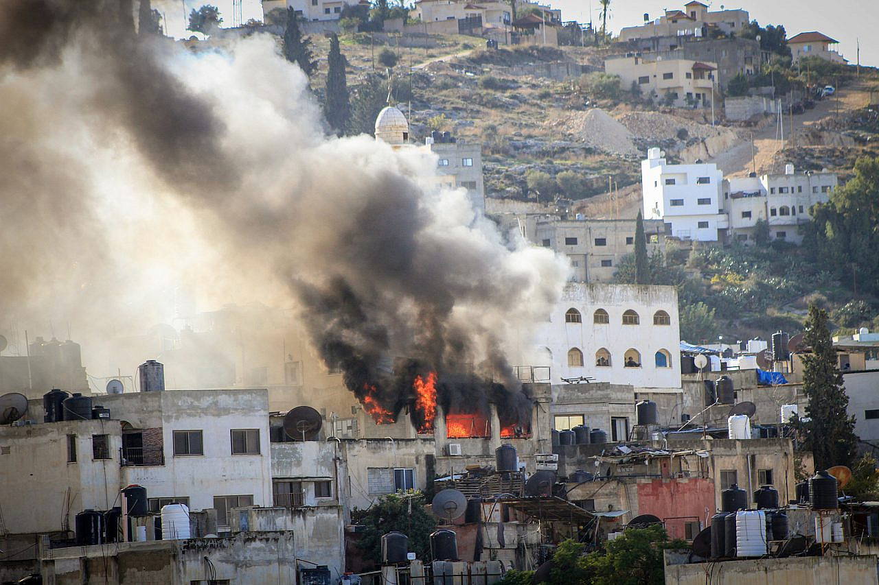 A building is seen on fire during a raid by Israeli forces in the occupied West Bank city of Jenin, December 13, 2023. (Nasser Ishtayeh/Flash90)