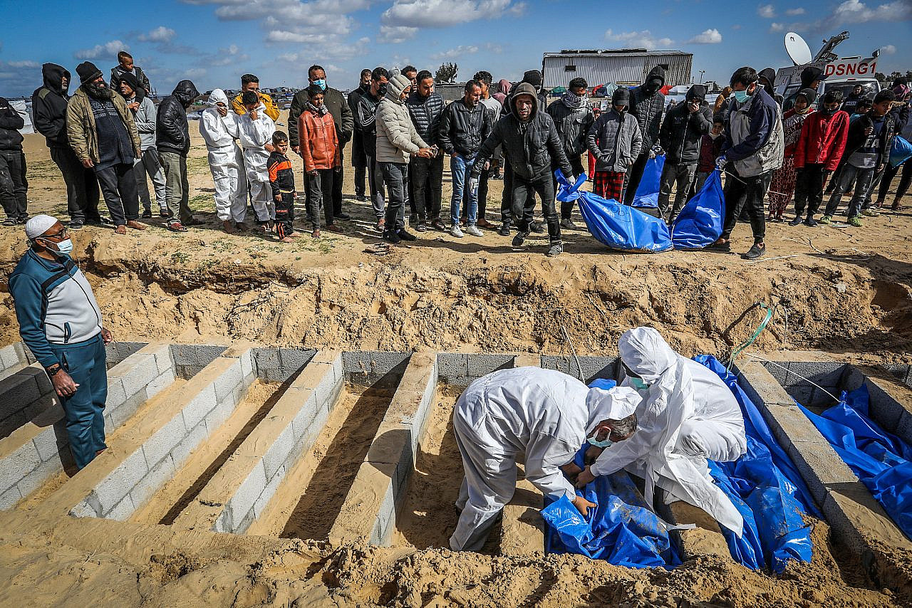 Palestinians bury bodies in a mass grave in Rafah, southern Gaza Strip, January 30, 2024. (Abed Rahim Khatib/Flash90)