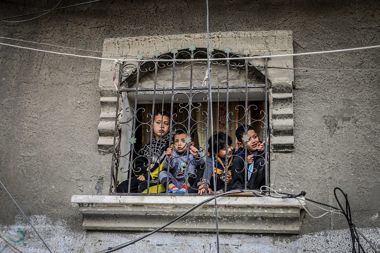 Palestinians children look out of a window at the site of an Israeli airstrike in the city of Rafah, southern Gaza Strip, February 16, 2024. (Abed Rahim Khatib/Flash90)