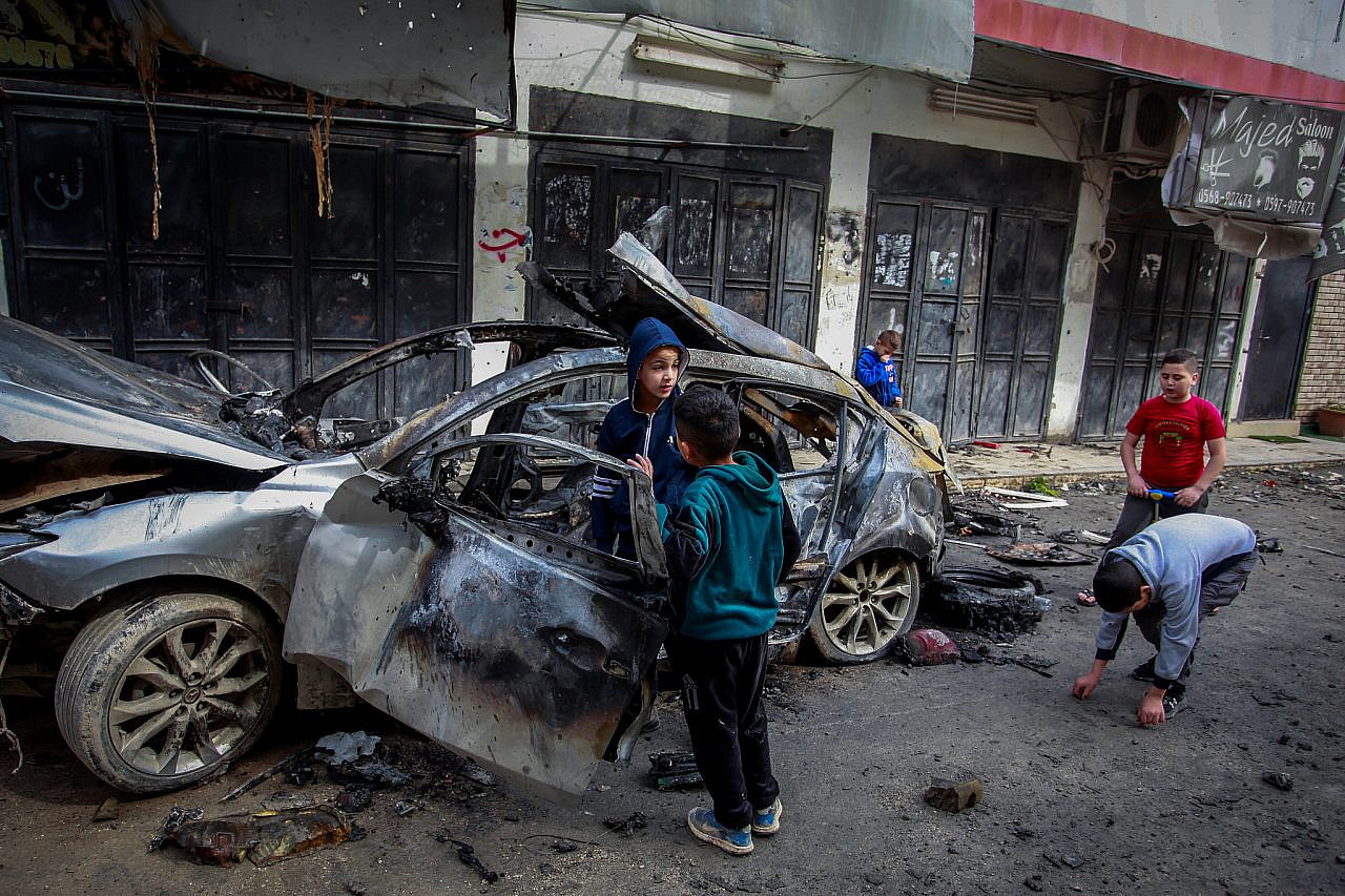 Palestinians inspect a car that was hit by an Israeli airstrike overnight, in the occupied West Bank city of Jenin, February 23, 2024. (Nasser Ishtayeh/Flash90)