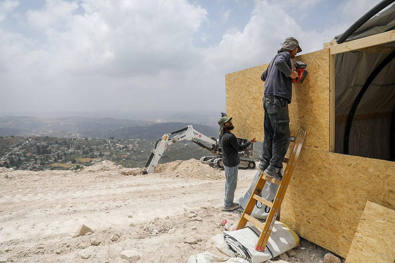 Izraelio naujakuriai pastato konstrukciją Homesh forposte, okupuotame Vakarų Krante, 29 m. gegužės 2023 d. (Flash90)