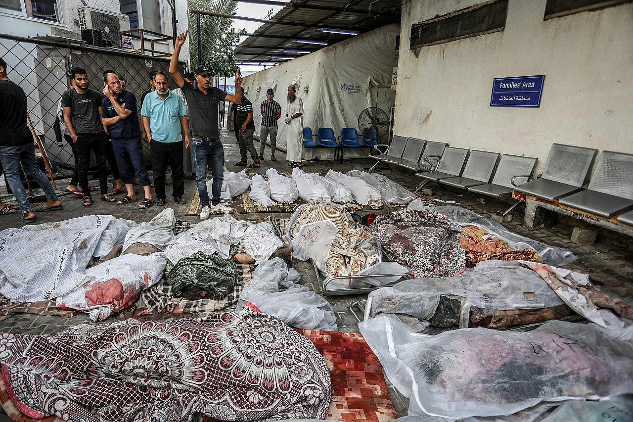 Los palestinos esperan recibir los cuerpos de sus familiares que murieron en un ataque aéreo israelí, en el hospital Al-Najjar en Rafah, sur de la Franja de Gaza, el 24 de octubre de 2023. (Abed Rahim Khatib/Flash90)