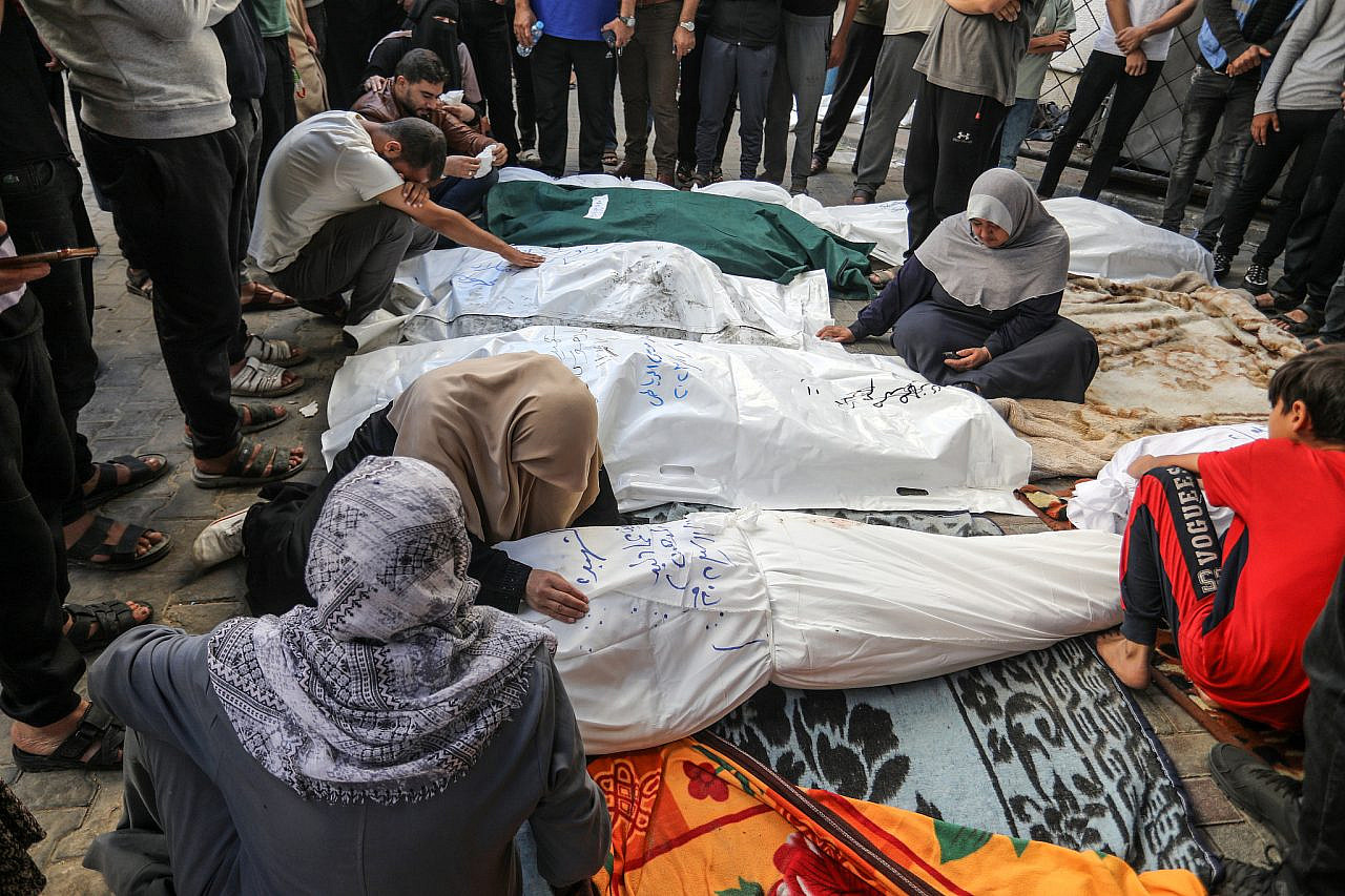 Los palestinos esperan recibir los cuerpos de sus familiares que murieron en los ataques aéreos israelíes, en el Hospital Al-Najjar en Rafah, sur de la Franja de Gaza, el 7 de noviembre de 2023. (Abed Rahim Khatib/Flash90)