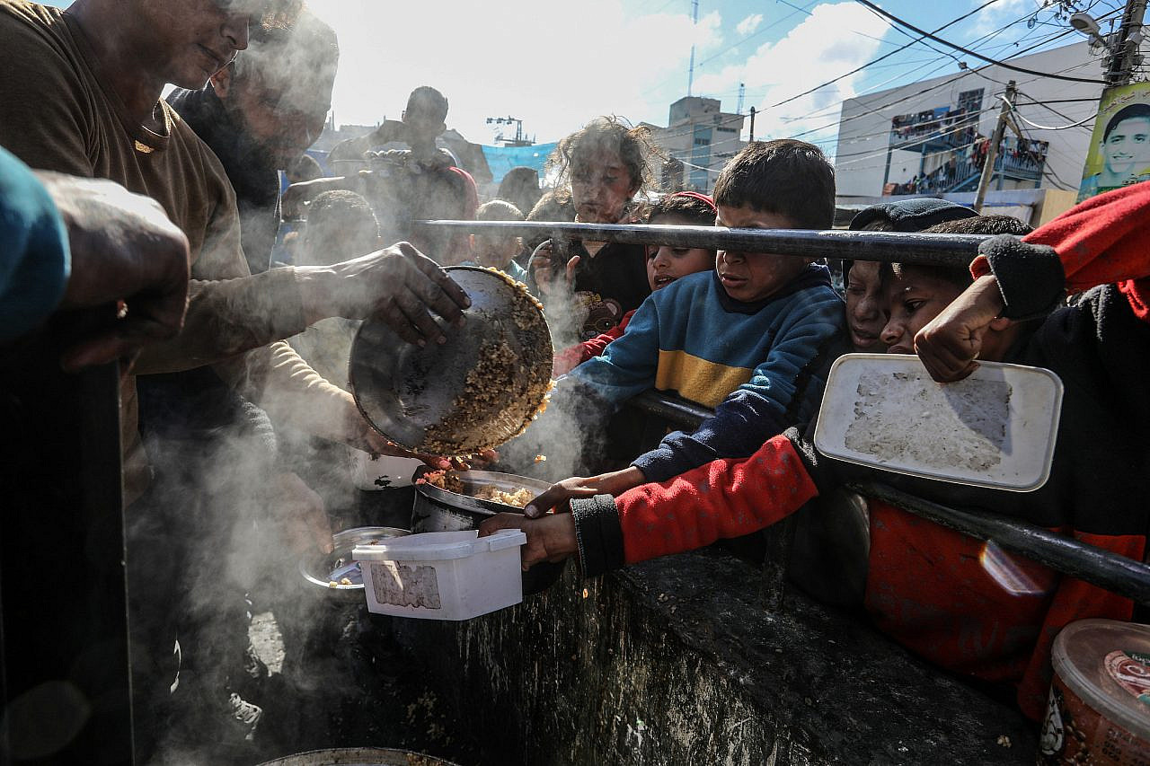 Palestinians wait for a hot meal prepared by volunteers in Rafah, southern Gaza Strip, February 9, 2024. (Abed Rahim Khatib/Flash90)