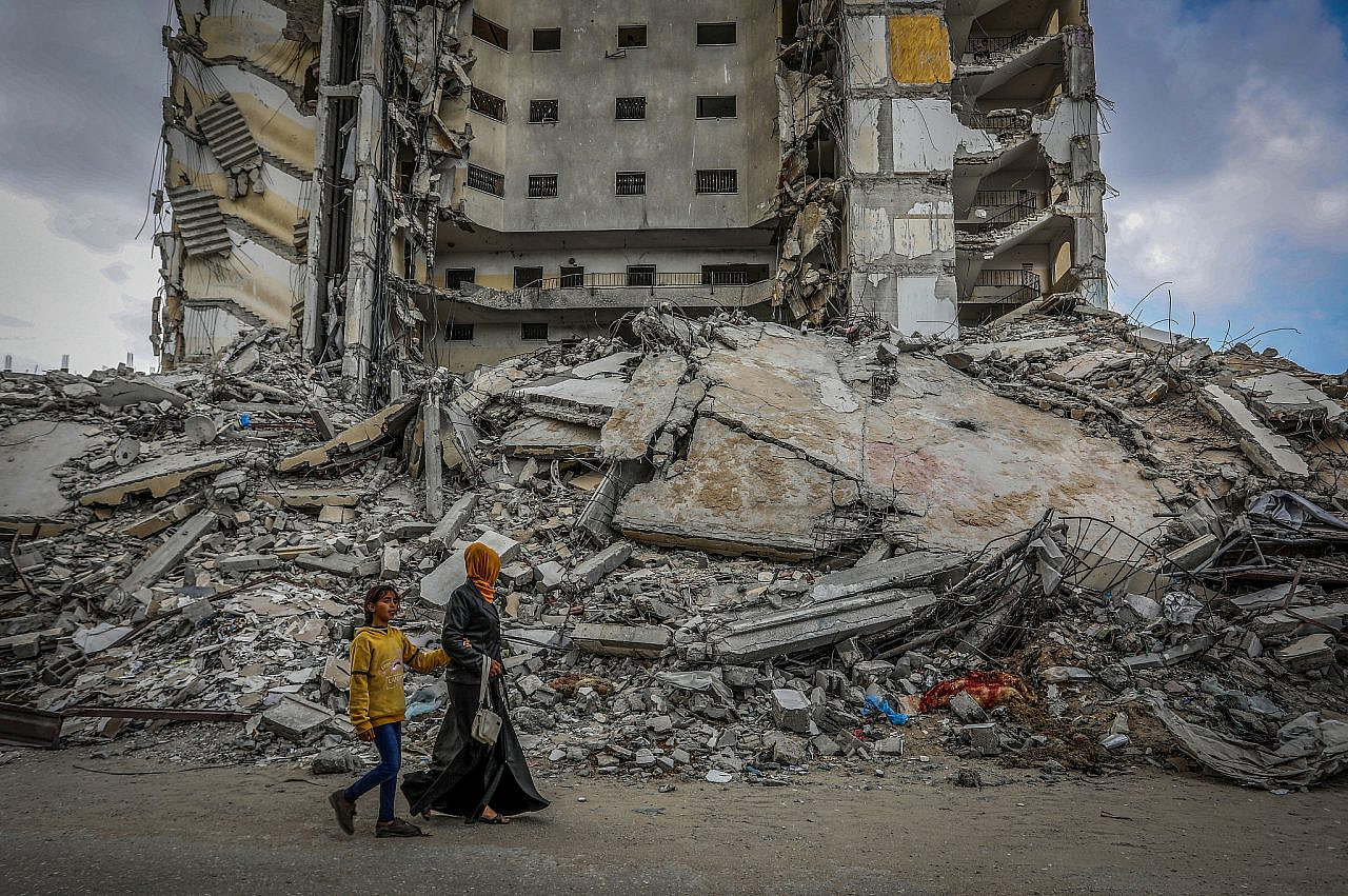 Palestinos en el lugar de un edificio destruido por un ataque aéreo israelí en Rafah, en el sur de la Franja de Gaza, el 18 de marzo de 2024. (Abed Rahim Khatib/Flash90)