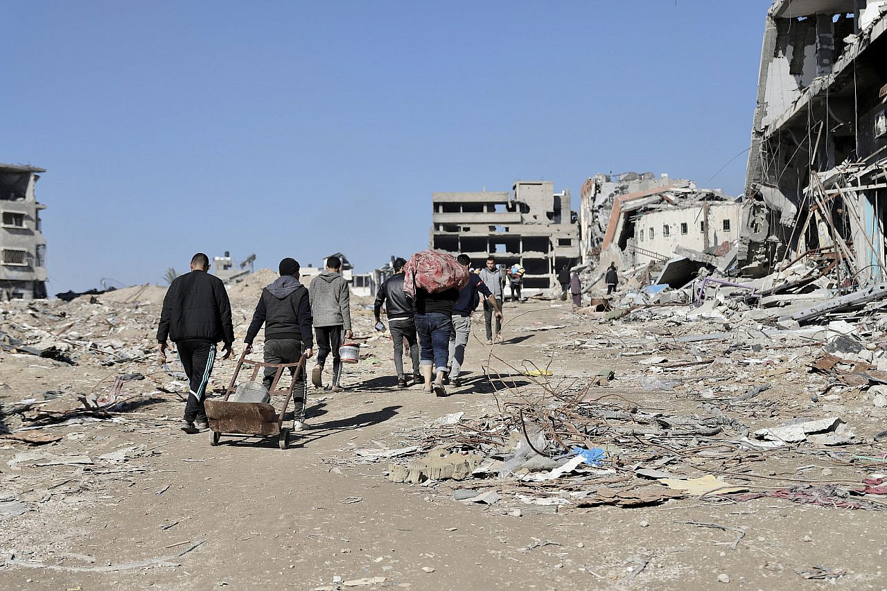 Palestinians walk amid the rubble of Shuja'iya, northern Gaza, February, 2024. (Mohammed Hajjar)