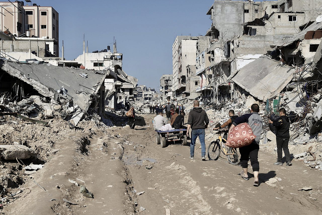 Palestinians walk amid the rubble of Shuja'iya, northern Gaza, February, 2024. (Mohammed Hajjar)