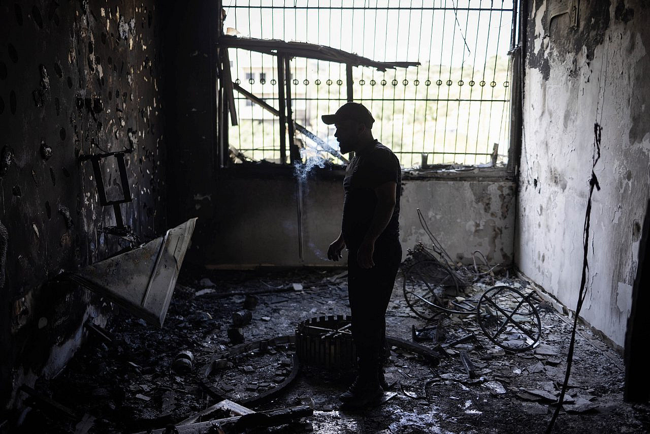 Palestinians inspect the damage to a house that was burned by settlers during a pogrom in Duma, occupied West Bank, April 14, 2024. (Oren Ziv)