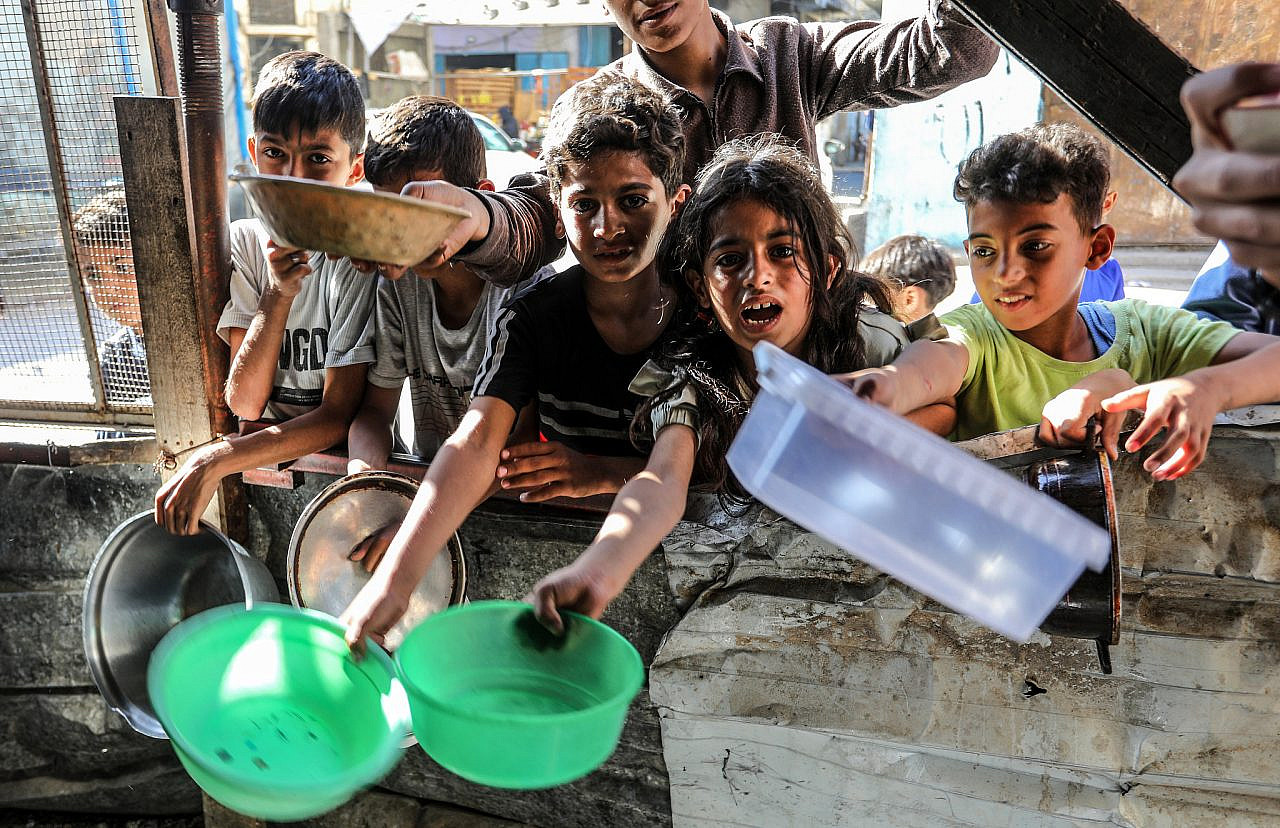 Palestinian children wait for a hot meal prepared by volunteers in Rafah, southern Gaza Strip, April 4, 2024. (Abed Rahim Khatib/Flash90)