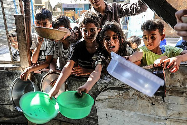 Palestinian children wait for a hot meal prepared by volunteers in Rafah, southern Gaza Strip, April 4, 2024. (Abed Rahim Khatib/Flash90)