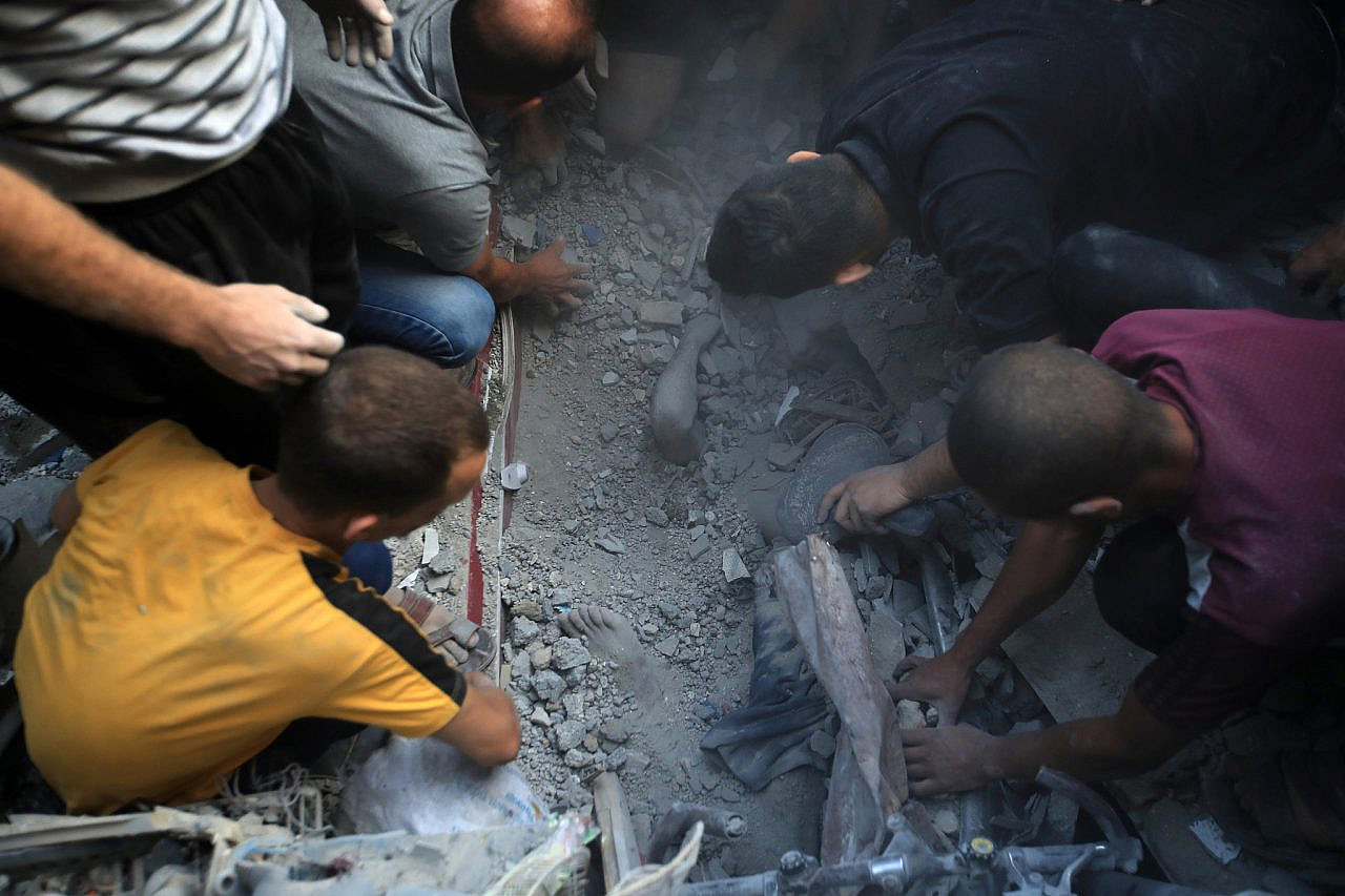 Los palestinos que cavan con manos de oso encuentran un cadáver entre los escombros después de un ataque aéreo israelí que mató a decenas de palestinos en medio del campo de refugiados de Al-Maghazi, en el centro de la Franja de Gaza, el 5 de noviembre de 2023. (Mohammed Zaanoun/Activestills)