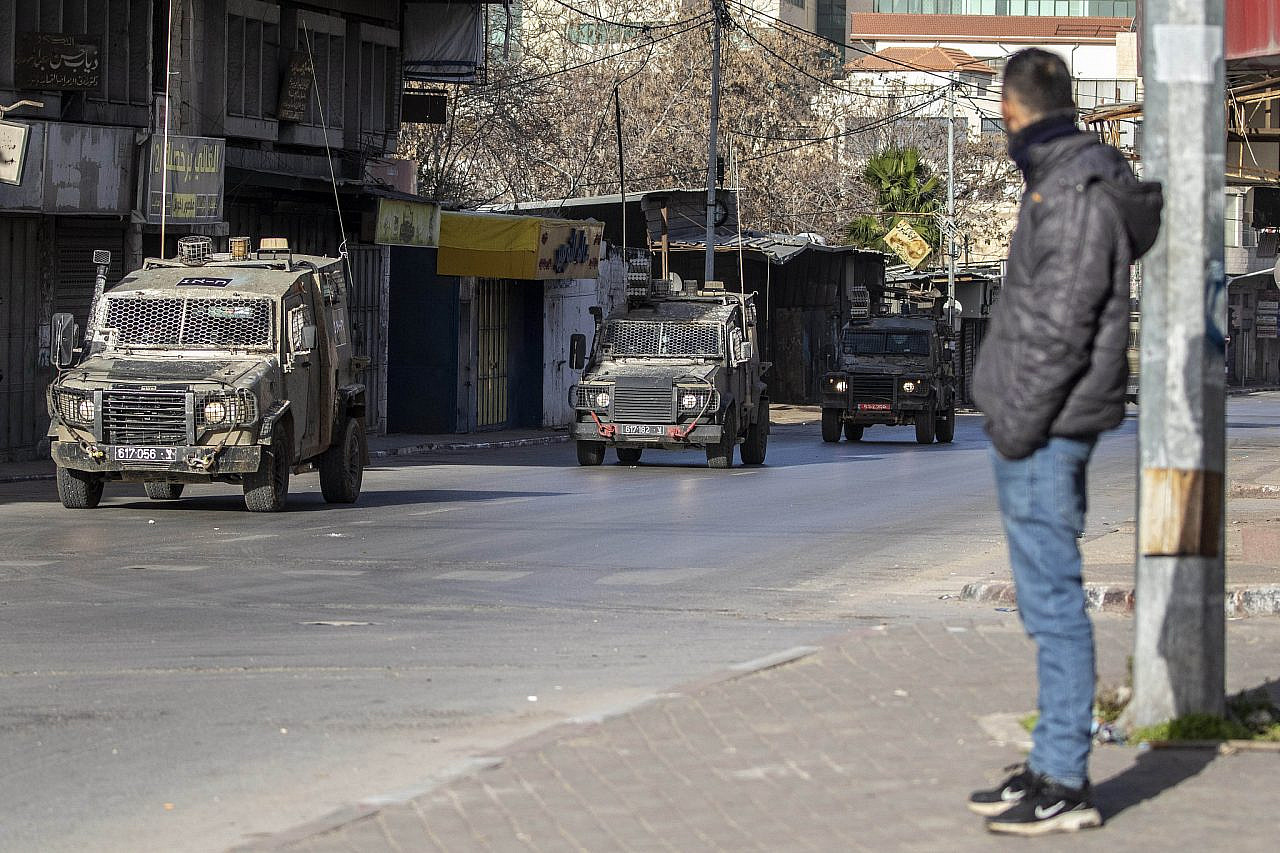 Palestinians watch as Israeli military jeeps storm the occupied West Bank city of Nablus, January 10, 2024. (Wahaj Bani Moufleh/Activestills)