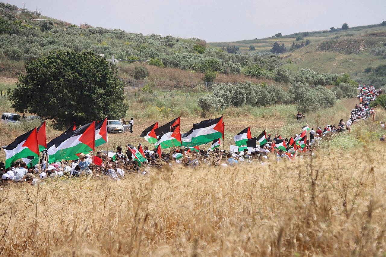 Protesters wave Palestinian flags during the 27th annual March of Return in the depopulated villages of Hawsha and Al-Kasair, northern Israel, May 14, 2024. (Ahmad Al-Bazz)