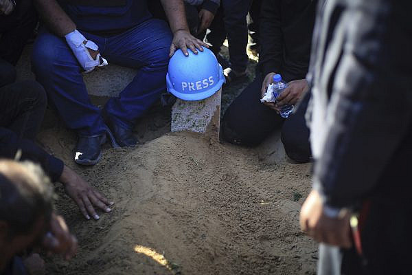 A press helmet is placed over the grave of Hamza Dahdouh, a Palestinian journalist who worked for Al Jazeera and the son of Al Jazeera's Gaza bureau chief Wael Dahdouh, who was killed in an Israeli drone strike on Rafah, January 7, 2024. (Mohammed Talatene/picture-alliance/dpa/AP Images)
