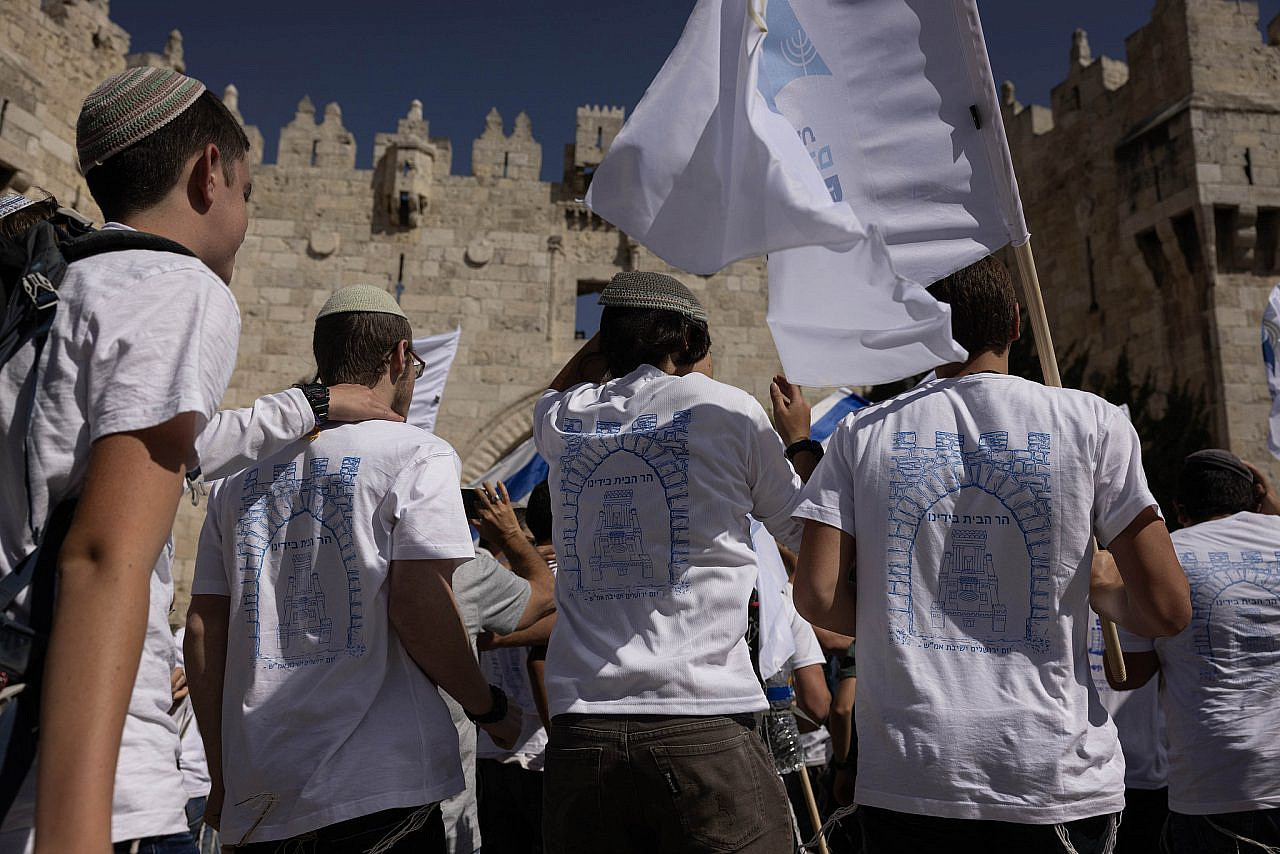 Israelis wearing T-shirts calling to rebuild a Jewish temple on the Temple Mount/Al-Aqsa Mosque gather for the Flag March at Damascus Gate, Old City of Jerusalem, June 5, 2024. (Oren Ziv)