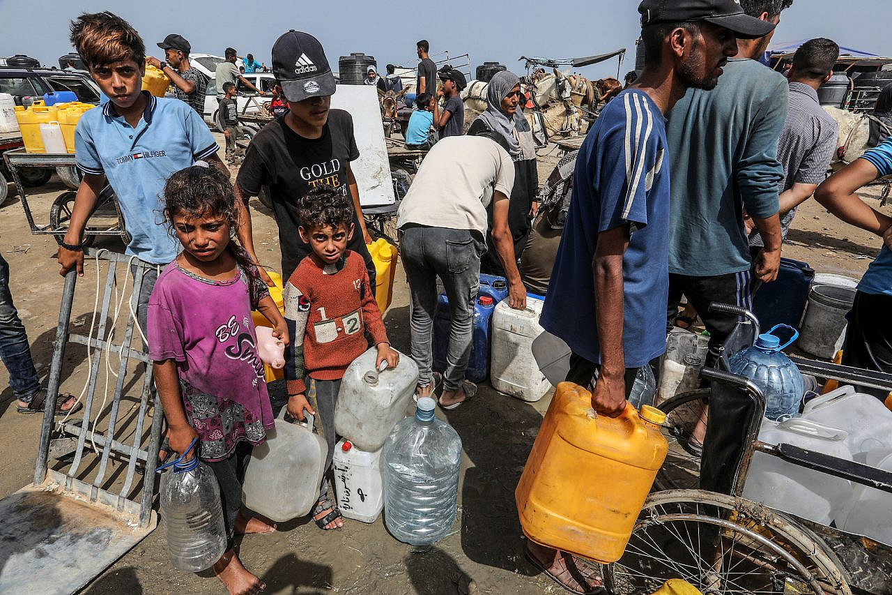Palestinians line up to receive drinkable water in Deir al-Balah, central Gaza Strip, May 20, 2024. (Abed Rahim Khatib/Flash90)