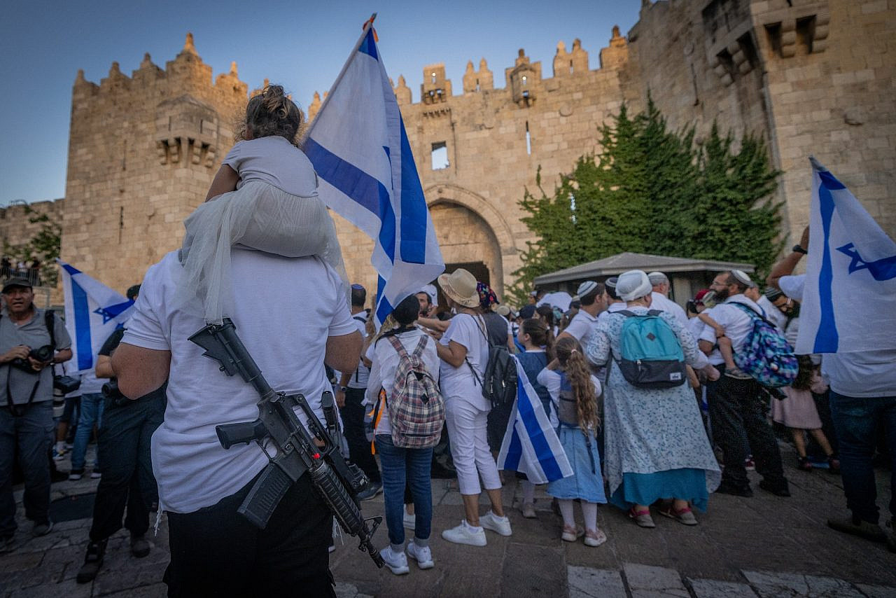 Jewish men hold Israeli flags as they dance at the Damascus Gate in Jerusalem's Old City during Jerusalem Day celebrations on June 5, 2024. Photo by Chaim Goldberg/Flash90