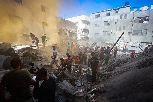 Palestinians search for martyrs and wounded in the rubble of a destroyed building after an Israeli airstrike in Khan Younis, southern Gaza Strip, November 6, 2023. (Atia Mohammed/Flash90)