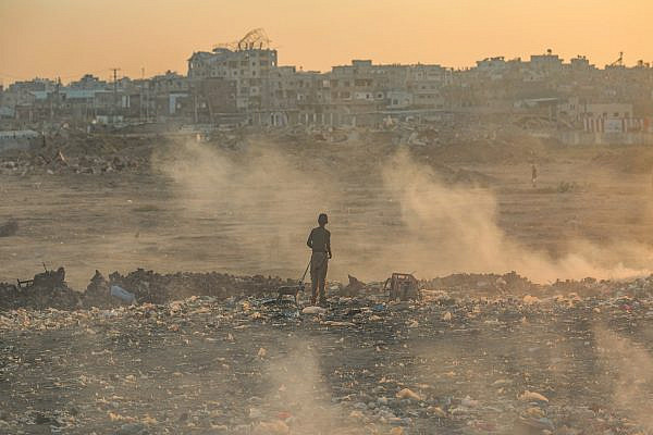 Palestinian boy walks through rubble amid ongoing Israeli attacks, in Al-Bureij refugee camp in the central Gaza Strip, July 22, 2025. (Ali Hassan/Flash90)