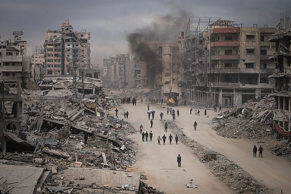 Palestinians walk among the ruins of their homes in the Shuja'iya neighborhood of eastern Gaza, October 16, 2025. (Khalil Kahlout/Flash90)