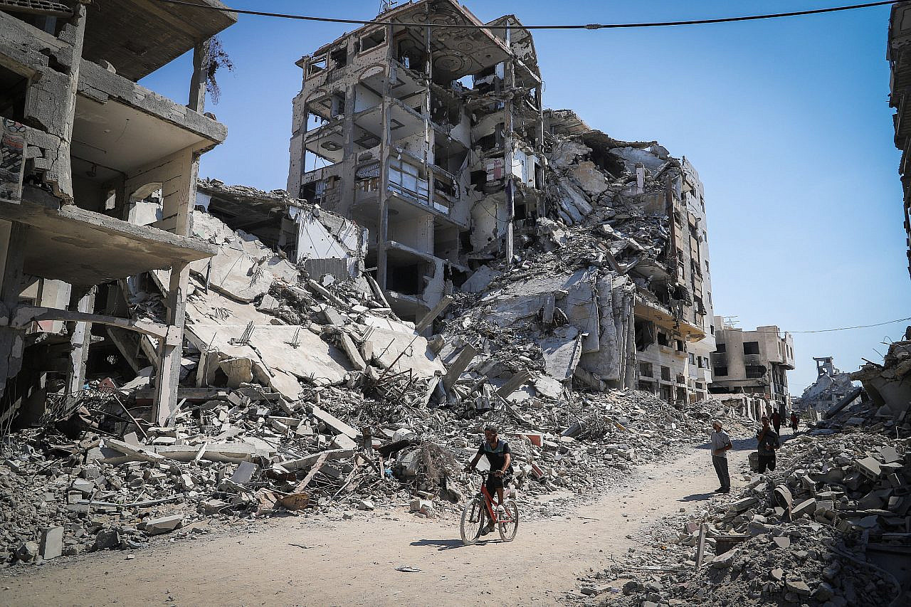 Palestinians walk among the ruins of their homes in the northern Gaza Strip, October 22, 2025. (Khalil Kahlout/Flash90)