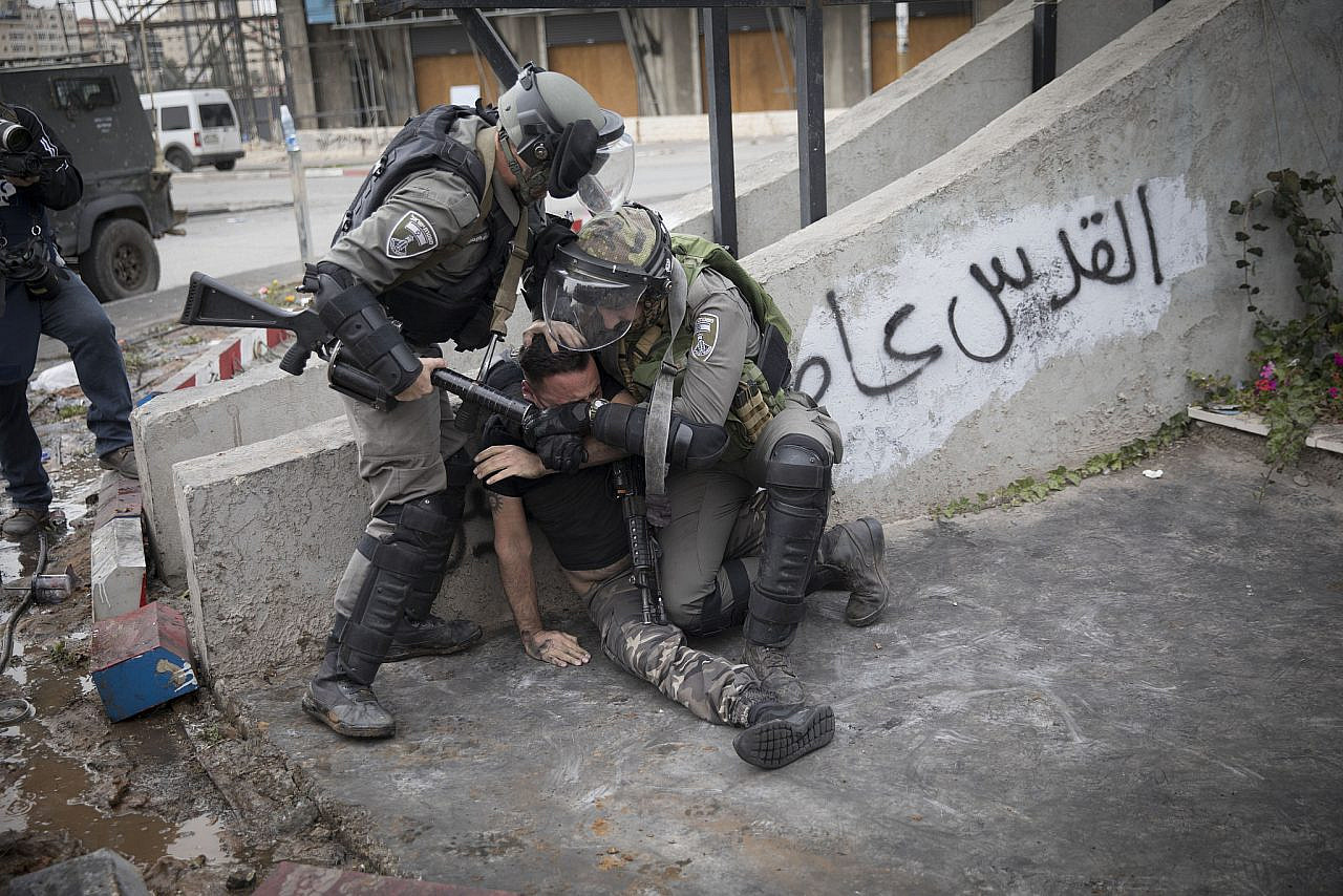 Israeli Border Police officers violently arrest a Palestinian protester near the Beit El checkpoint, north of Ramallah, occupied West Bank, December 22, 2017. (Oren Ziv)