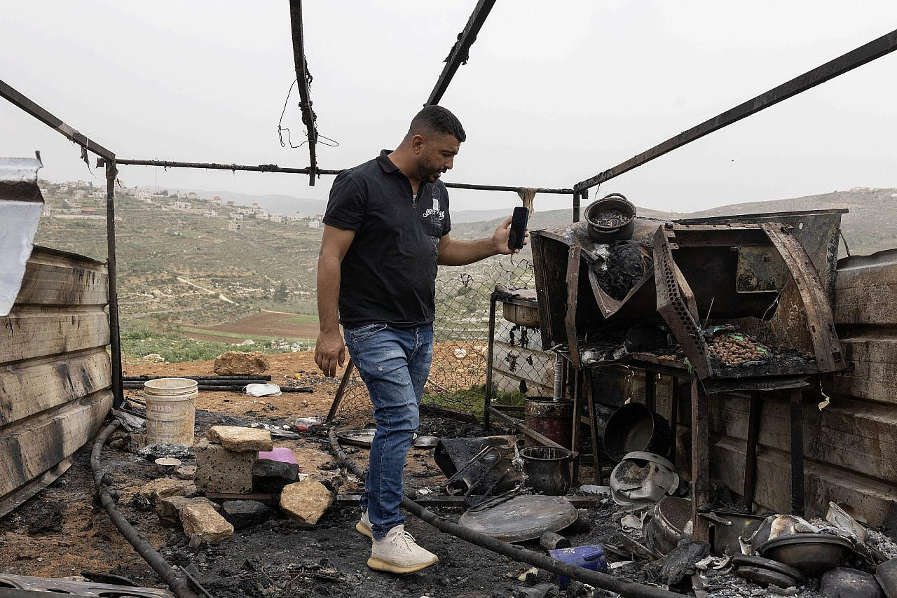 Ayman Ghrayeb documents the aftermath of an Israeli settlers attack in Sinjil, occupied West Bank, April 23, 2025. (Oren Ziv)