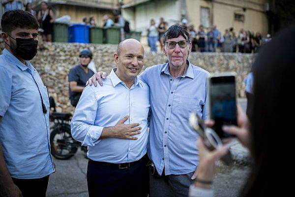 Naftali Bennett poses for pictures with supporters while awaiting the arrival of Evyatar David, an Israeli hostage freed from Hamas captivity, outside David’s home in Kfar Saba, October 26, 2025. (Erik Marmor/Flash90)